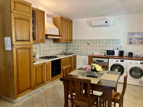 eine Küche mit einem Tisch und einem Esszimmer in der Unterkunft Villa Grecale in Cala Liberotto