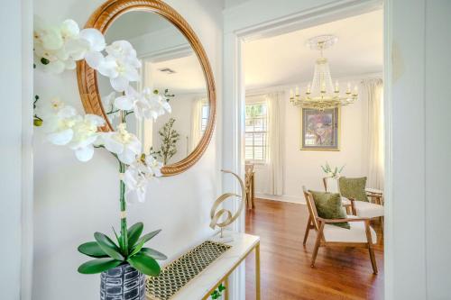 een woonkamer met een spiegel en een vaas met bloemen bij Serene 4 Bedroom Home near French Quarter with Wi-Fi and Parking in New Orleans