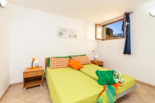 a bedroom with a green bed and a window at VILLE MONDO a 350 metri dalla spiaggia in Àrbatax