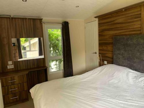 1 dormitorio con 1 cama blanca y 2 ventanas en Luxury spacious house with two bathrooms and swimming pool, en Voorthuizen