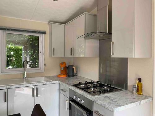 a kitchen with a stove and a sink at Luxury spacious house with two bathrooms at park with swimming pools, restaurant, bowling, massage & wellness in Voorthuizen