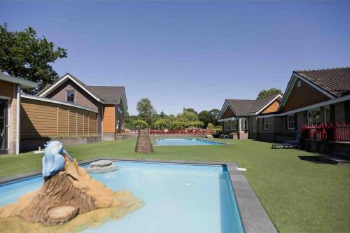 una piscina con una estatua de un pelícano en un patio en Luxury spacious house with two bathrooms and swimming pool, en Voorthuizen