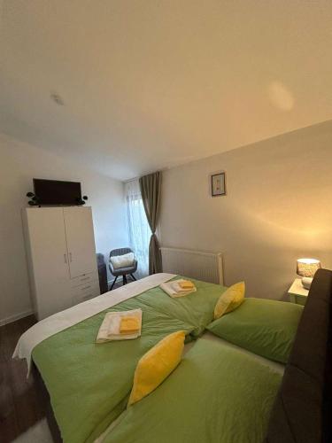 a bedroom with a green bed with two pillows on it at Cazare La Luiza b in Şura Mare