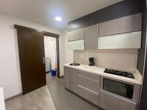 a kitchen with stainless steel appliances and a brown door at Aldea Comercial Condominio Ruitoque Golf in Floridablanca