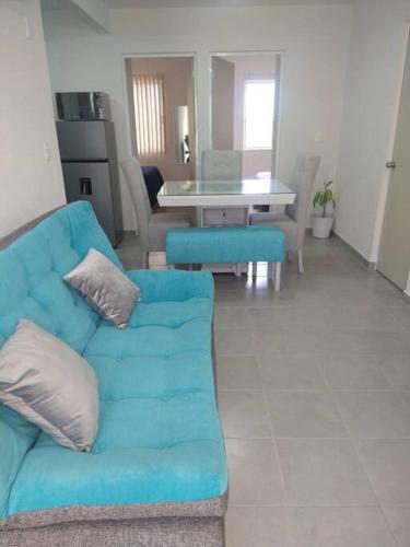 a living room with a blue couch and a table at Acapulco Dreamer Diamante II in Gallinero