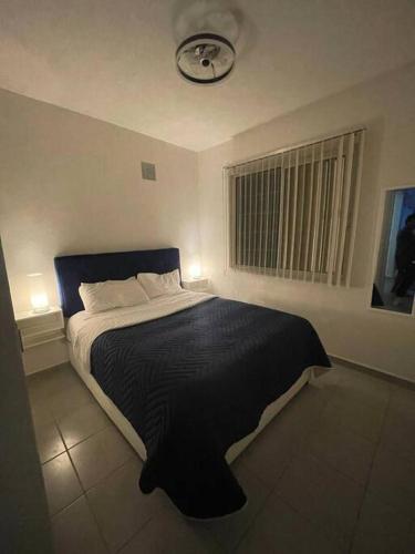 a bedroom with a bed with a clock on the wall at Acapulco Dreamer Diamante II in Gallinero