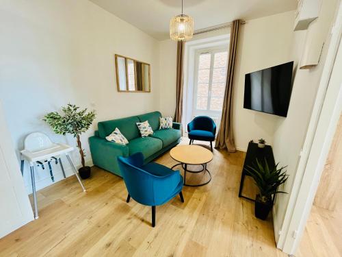 un salon avec un canapé vert et une table dans l'établissement Le Caterina - T4 entre Loire et Château Royal - Manoir de la Concorde, à Amboise