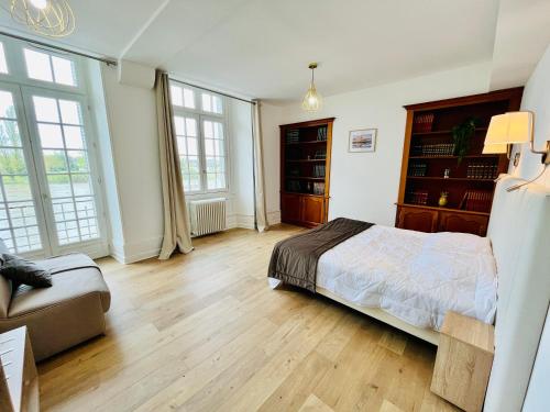 - une chambre avec un lit, un canapé et des fenêtres dans l'établissement Le Caterina - T4 entre Loire et Château Royal - Manoir de la Concorde, à Amboise