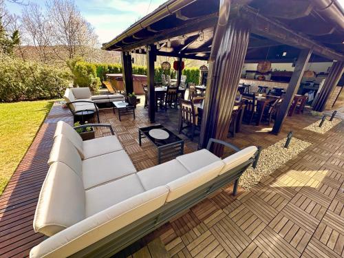 a patio with a white couch on a wooden deck at Villa Mukinja - Wellness & Spa in Plitvička Jezera