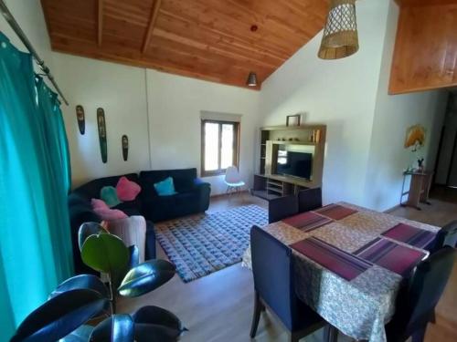 een woonkamer met een bank en een tafel bij Refugio en la ciudad in Pucón