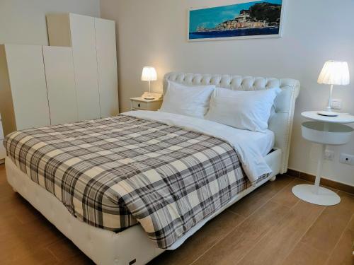 um quarto com uma cama branca e um cobertor xadrez em Villa Livia - L'Opera Group em La Spezia