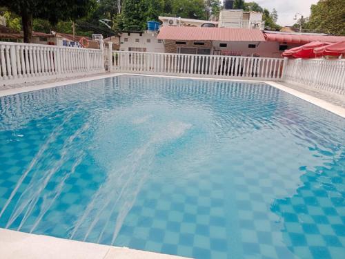 una gran piscina azul con una valla blanca en Cabaña Condominio Hacaritama, en Melgar