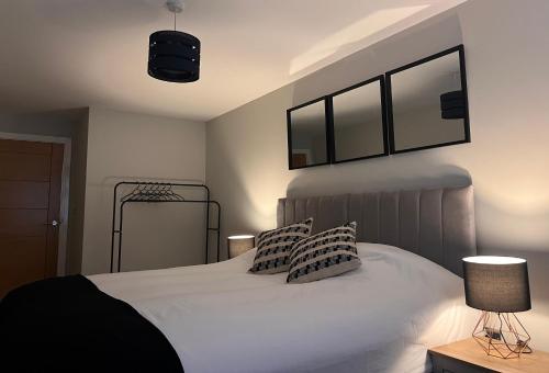 um quarto com uma cama branca e 2 almofadas em Cosy Suite in Shirley em Solihull