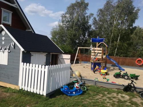 a backyard with a play area with a playground at Domki Kapitańskie Lubiatowo in Lubiatowo