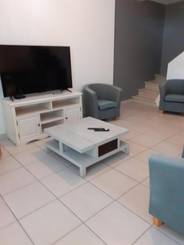 un salon avec une télévision, une table et des chaises dans l'établissement Les Allées, à Valence