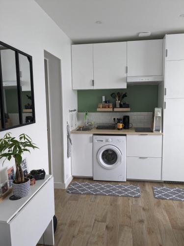 a kitchen with white cabinets and a washing machine at Cosy appartement / stade de France / portes paris in Saint-Denis
