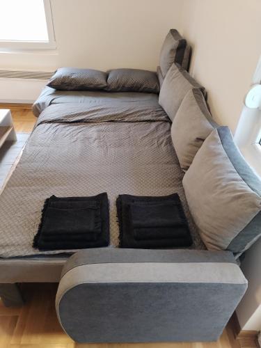 een bed met twee kussens in een kamer bij Marko apartman in Surčin