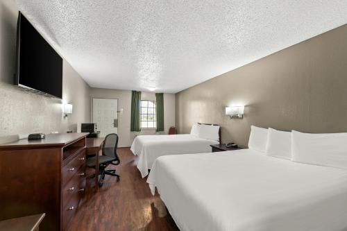 Cette chambre comprend deux lits et un bureau. dans l'établissement Americas Best Value Inn Bonham, à Bonham