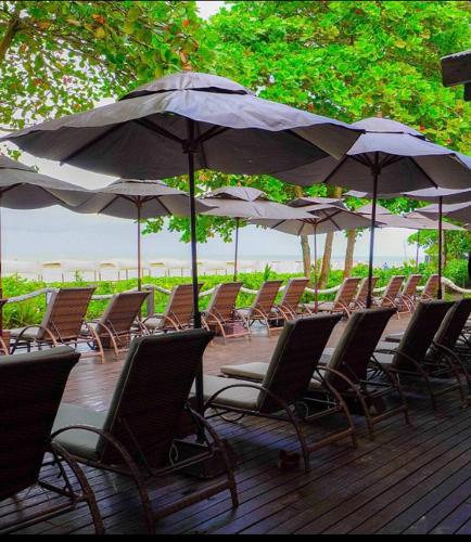 a bunch of chairs and umbrellas on a deck at Resort All Inclusive Arcobaleno in Porto Seguro