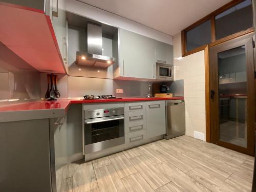 een keuken met roestvrijstalen apparatuur en rode aanrechtbladen bij Vitalba Apartments in Lanjarón