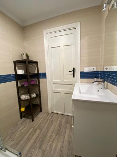 een badkamer met een wastafel en een witte deur bij Vitalba Apartments in Lanjarón