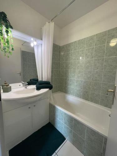 a bathroom with a tub and a sink and a bath tub at Villa Tia - Appartement 2 chambres - piscine - bord de lac in Saint-Saturnin-lès-Avignon