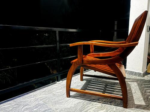 a wooden rocking chair sitting on a porch at Serene Stay in Kurunegala