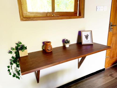 a wooden shelf on a wall with a window at Serene Stay in Kurunegala