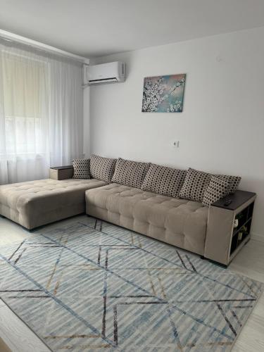una sala de estar con un sofá marrón en una habitación en Apartament Central en Râmnicu Vâlcea