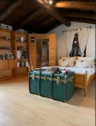 a bedroom with a bed with a green trunk at Rustico al Sasso in Gerra