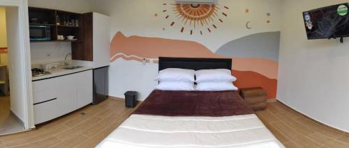 um quarto com uma cama e uma cozinha com uma parede em VerdeSelva em Doradal