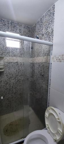 Camassari的住宿－Pousada e Hostel clubhouse，一间带卫生间和玻璃淋浴间的浴室