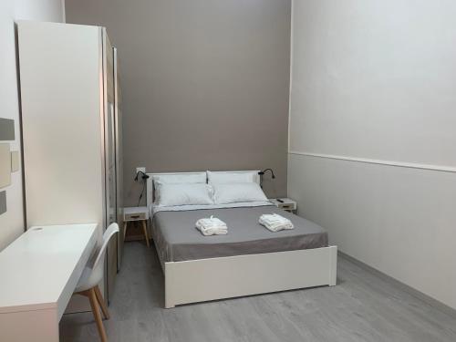 a small bedroom with a bed with towels on it at AngelHome Matera in Matera