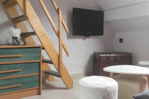 - un salon avec un escalier et une télévision murale dans l'établissement Appartement de 2 à 6 personnes, à Cauterets