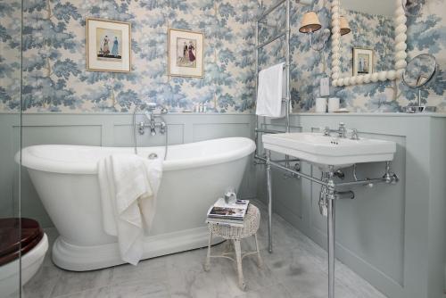 a bathroom with a tub and a sink at Wood Cottage in Coldstream