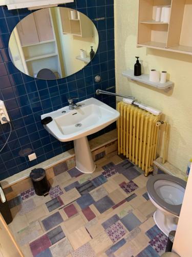 une salle de bain avec un lavabo, des toilettes et un miroir dans l'établissement Chambre privée dans Maison d'hotes 10 minutes à pied de la gare et du centre, à Alès
