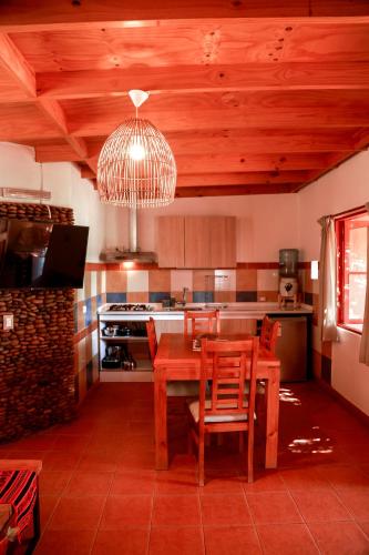 a kitchen with a wooden table and wooden ceilings at Tambo Atacama Lodge in San Pedro de Atacama