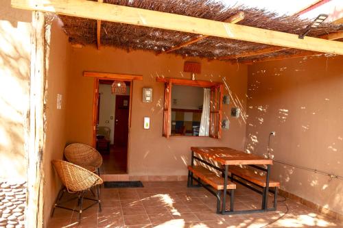 a porch with a wooden table and a bench at Tambo Atacama Lodge in San Pedro de Atacama