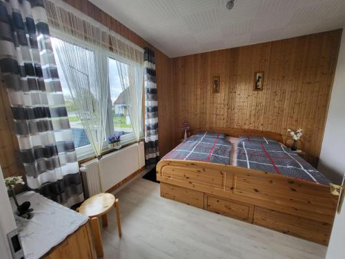 a bedroom with a wooden bed and a window at Ferienwohnung Emira in Wittingen