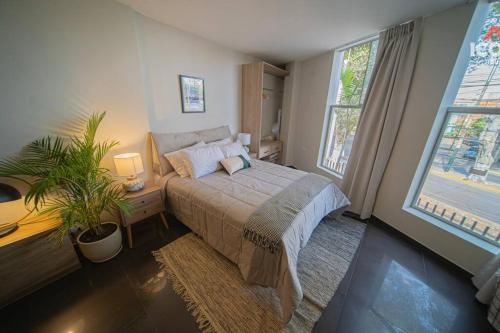 a bedroom with a bed and two windows at Elegant Studio in Barranco in Lima