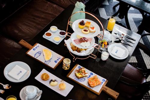 a table with plates of breakfast food on it at Fera Palace Hotel in Salvador