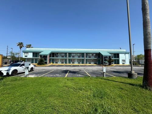 a building with a car parked in a parking lot at Nola Inn & Suites in New Orleans