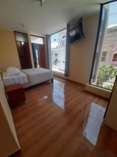 a bedroom with a bed and a large window at Hotel Samanahuasi nasca in Nazca