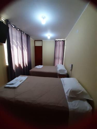 Habitación de hotel con 2 camas y ventana en Hotel Samanahuasi nasca en Nazca