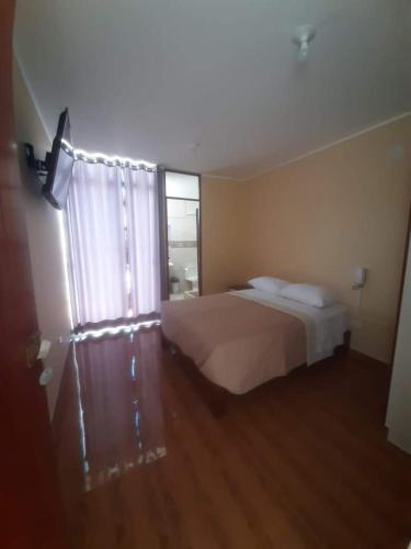 a bedroom with a bed and a large window at Hotel Samanahuasi nasca in Nazca