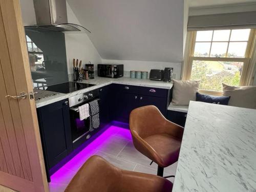 a kitchen with a purple light in the floor at The Loft at Scalford House in Melton Mowbray