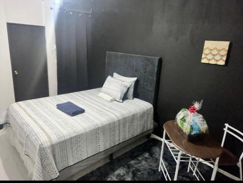 a small bedroom with a bed and a table at Habitación #2 in San Salvador