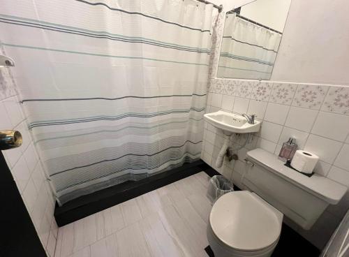 y baño con aseo, lavabo y ducha. en Habitación #2 en San Salvador