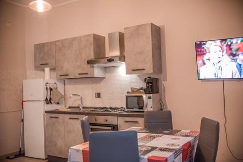 una cucina con tavolo e TV a parete di Appartamento Gufetto a Banchette