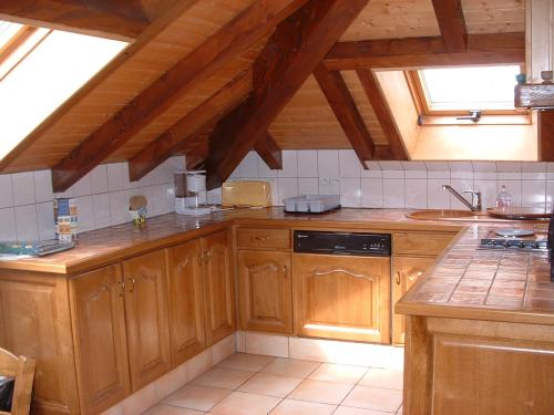 a kitchen with wooden cabinets and a sink at Appt 4 pers-chalet l'ancienne école in La Bresse